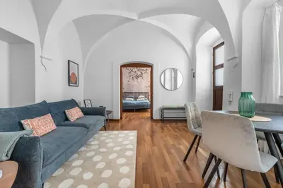 a living room with a blue couch and a table at Cozy apartment in the Old town in Prague