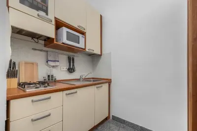 a kitchen with white cabinets and a microwave at Cozy apartment in the Old town in Prague