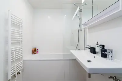 a white bathroom with a sink and a mirror at Bright Royal Elegance in Prague