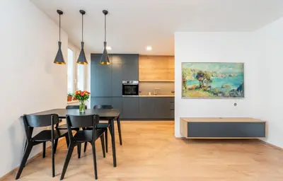 a kitchen and dining room with a table and chairs at Luxury modern apartment near the metro - 10 minutes to the city center in Prague