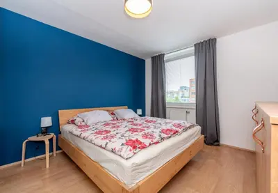 a bedroom with a bed with a blue wall at Luxury modern apartment near the metro - 10 minutes to the city center in Prague