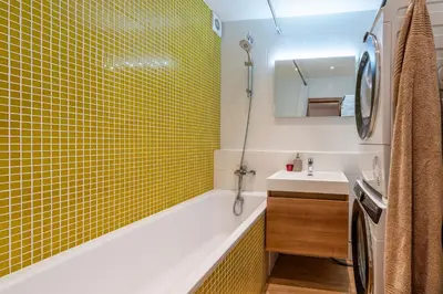 a bathroom with a yellow tiled tub and a sink at Luxury modern apartment near the metro - 10 minutes to the city center in Prague