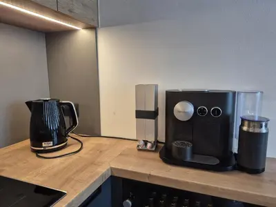 a kitchen counter with a coffee maker and a coffeemaker at Luxury modern apartment near the metro - 10 minutes to the city center in Prague