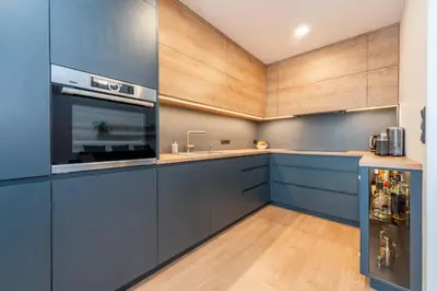a kitchen with blue cabinets and a sink at Luxury modern apartment near the metro - 10 minutes to the city center in Prague