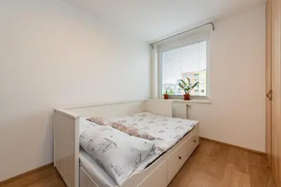 a bed in a room with a window at Luxury modern apartment near the metro - 10 minutes to the city center in Prague