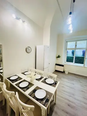 a dining room with a table with chairs and a refrigerator at Elegant Cozy Apartment In center Prague in Prague