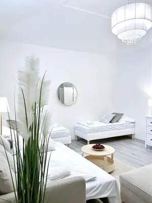 a white living room with two beds and a couch at Elegant Cozy Apartment In center Prague in Prague