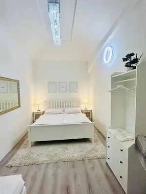 a bedroom with a white bed and a white cabinet at Elegant Cozy Apartment In center Prague in Prague