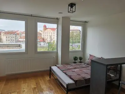 a bedroom with a bed and two windows at Glamour & Prague in Prague