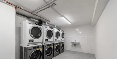 a laundry room with four washing machines and a sink at Glamour & Prague in Prague