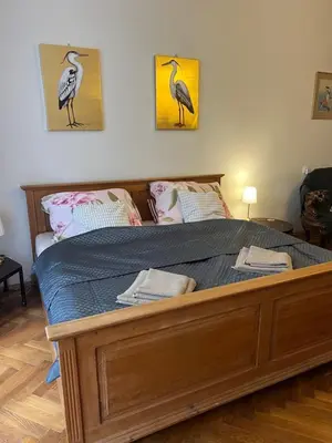 a bed in a bedroom with two birds on the wall at Štěpánká - Lucerna 1 in Prague