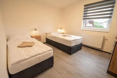 two beds in a room with a window at VH - Apartments