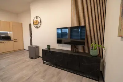 a living room with a flat screen tv on a stand at VH - Apartments