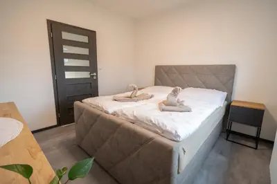 a bedroom with a bed with slippers on it at VH - Apartments