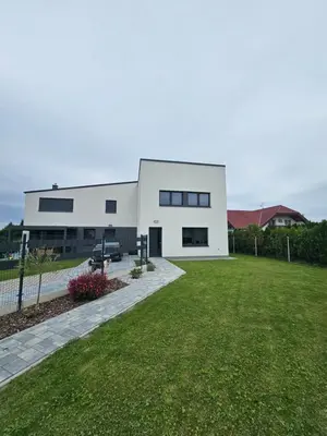 a white house with a lawn in front of it at VH - Apartments