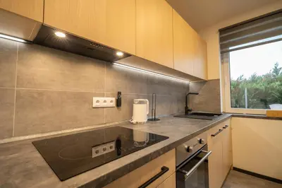 a kitchen with a sink and a large window at VH - Apartments