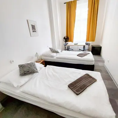 two twin beds in a room with a window at Soukromé křídlo pro 7 osob v Praze in Prague
