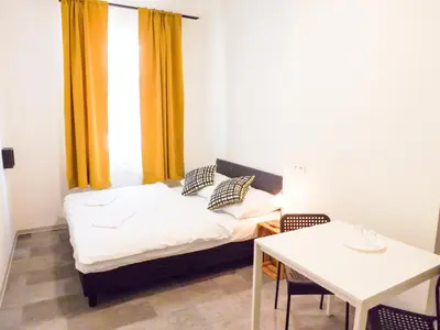 a small room with a bed and a table at Soukromé křídlo pro 7 osob v Praze in Prague