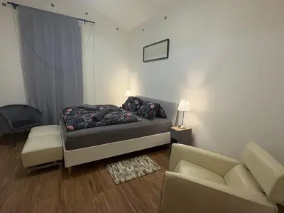 a bedroom with a bed and a couch and a chair at Riverside apartment in Prague