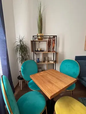 a table and green chairs in a room at Riverside apartment in Prague