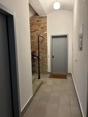 a hallway with a door and a brick wall at Riverside apartment in Prague