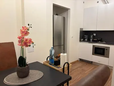 a living room with a table and a kitchen at Riverside apartment in Prague