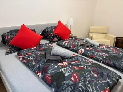 a bed with red pillows and a blanket on it at Riverside apartment in Prague