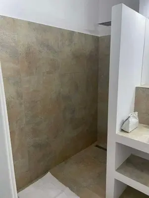 a bathroom with a shower with a brown wall at A beautiful cozy room in Prague in Prague