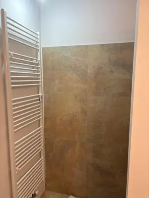 a bathroom with a shower with a tiled wall at A beautiful cozy room in Prague in Prague
