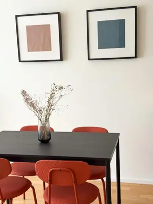 a dining room table with red chairs and a vase with flowers at New Modern Apartment in Center with Terrace and Parking in Prague