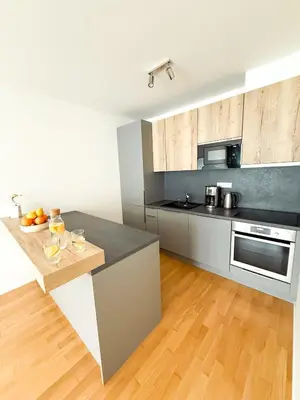 a kitchen with stainless steel appliances and a wooden floor at New Modern Apartment in Center with Terrace and Parking in Prague
