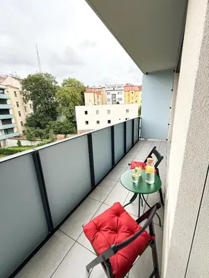a balcony with two chairs and a table with drinks on it at New Modern Apartment in Center with Terrace and Parking in Prague