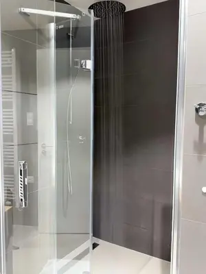 a shower with a glass door in a bathroom at New Modern Apartment in Center with Terrace and Parking in Prague
