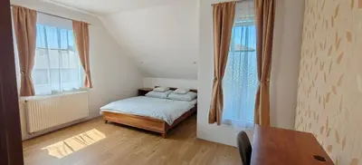 a small bedroom with a bed and two windows at Apartmán v Královském Údolí s předzahrádkou in Králŭv Dvŭr