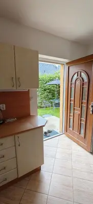 a kitchen with an open door to a patio at Apartmán v Královském Údolí s předzahrádkou in Králŭv Dvŭr