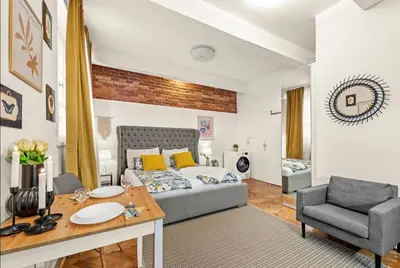 a living room with a bed and a table and a chair at Friendly Stay in Prague