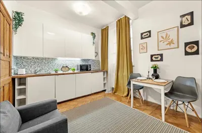 a kitchen and a living room with a couch and a table at Friendly Stay in Prague