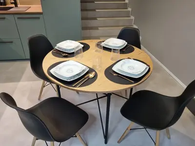 a wooden table with chairs and plates and napkins at Beautiful Duplex 20 min from center in Prague