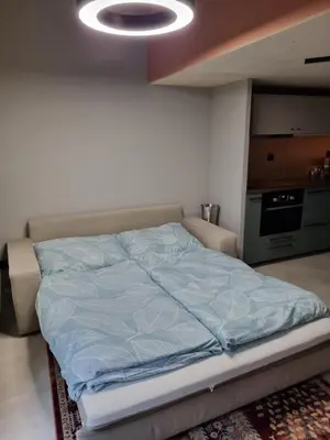 a bed with a blue comforter in a room at Beautiful Duplex 20 min from center in Prague