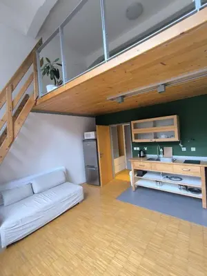 a living room with a white couch and a staircase at Loft Palmovka in Prague