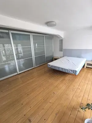 a bedroom with a bed in a room with wooden floors at Loft Palmovka in Prague