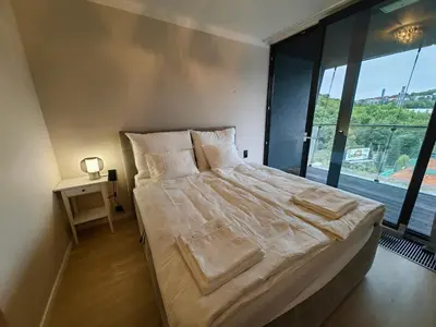 a large bed in a room with a large window at Free Parking Modern Smíchov Apartment With Large Balcony in Prague