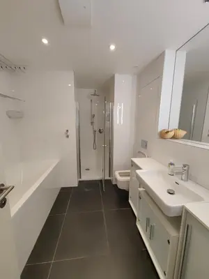 a white bathroom with two sinks and a shower at Free Parking Modern Smíchov Apartment With Large Balcony in Prague