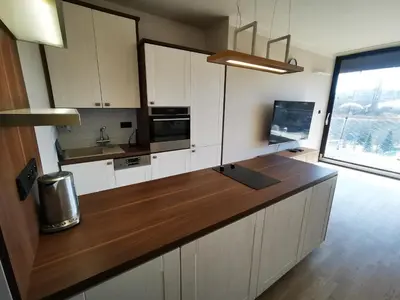 a kitchen with white cabinets and a wooden counter top at Free Parking Modern Smíchov Apartment With Large Balcony in Prague