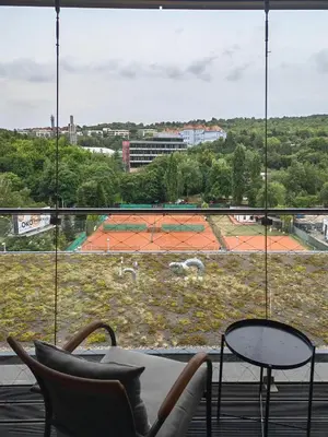 a room with chairs and a table and a large window at Free Parking Modern Smíchov Apartment With Large Balcony in Prague