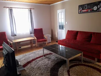 a living room with a red couch and a coffee table at Penzion Na Střelnici in Poděbrady