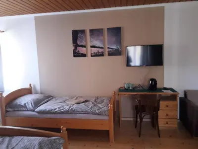 a bedroom with a bed and a desk and a table at Penzion Na Střelnici in Poděbrady