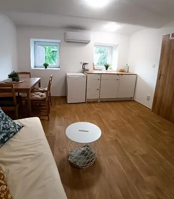 a living room with a table and a kitchen at Za hrází Poděbrady in Poděbrady