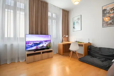 a living room with a television and a desk at Heart of the City Studio in Prague