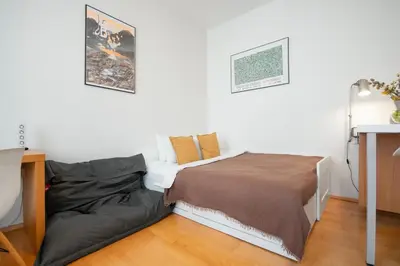 a small bedroom with a bed and a table at Heart of the City Studio in Prague